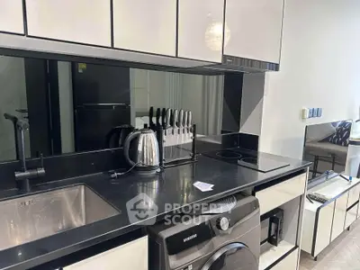 Modern kitchen with sleek black countertops, built-in appliances, and stylish cabinetry.