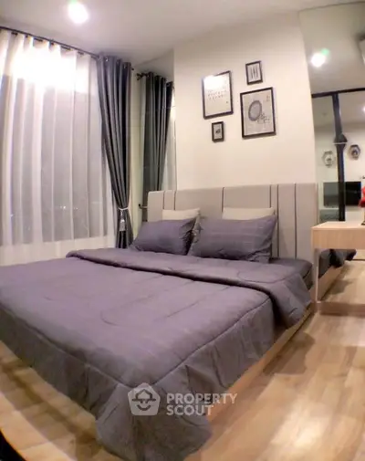 Modern bedroom with stylish decor and large window for natural light.