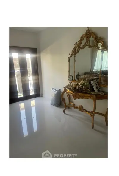 Elegant bedroom with ornate gold mirror and polished floors