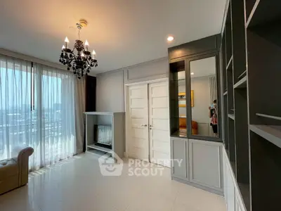 Elegant living room with chandelier, large windows, and stylish cabinetry