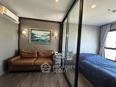 Modern studio apartment with glass partition, cozy living area, and stylish decor.