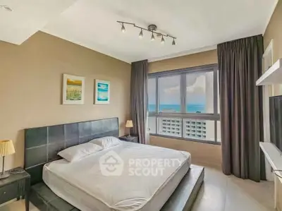 Luxurious bedroom with ocean view, modern decor, and large windows for natural light.