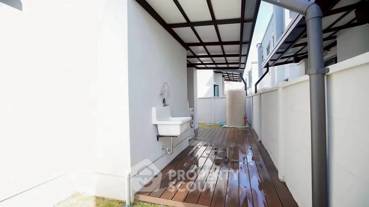 Modern exterior walkway with wooden deck and outdoor sink