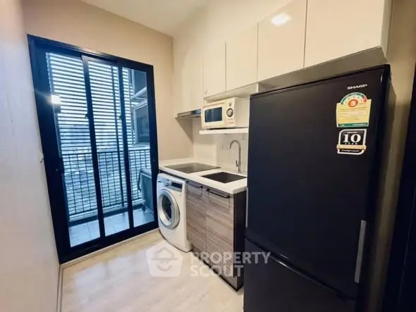 Modern kitchen with washing machine and fridge in compact layout