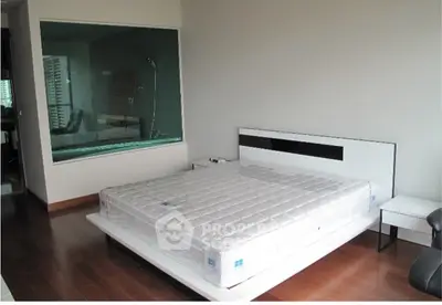 Modern bedroom with sleek design and large window for natural light.