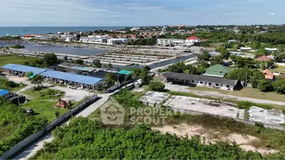 Aerial view of a coastal residential area with lush greenery and water features.
