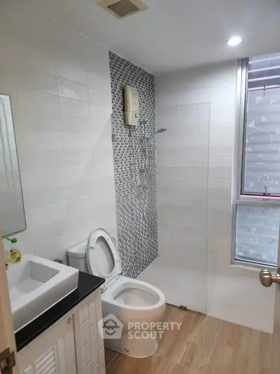 Modern bathroom with sleek design, featuring a glass shower enclosure and stylish tile accents.