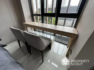 Modern study nook with sleek desk and chairs by large windows in urban apartment