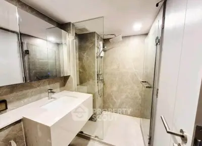 Modern bathroom with sleek design, featuring a glass shower enclosure and elegant vanity.