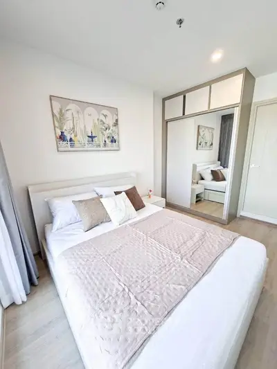 Modern bedroom with stylish decor and large mirrored wardrobe in a bright apartment.