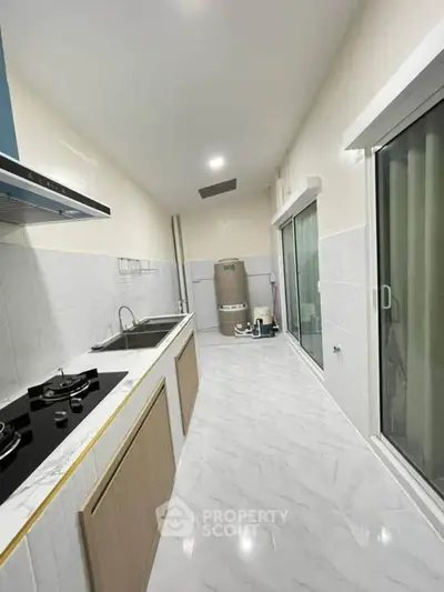 Modern kitchen with sleek design and gas stove in a bright, spacious layout.