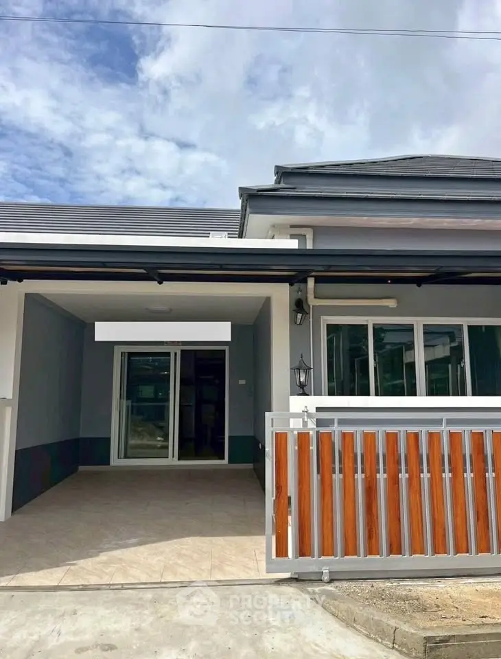 Charming single-story home with modern facade and spacious driveway.