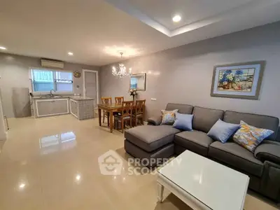 Spacious open-plan living room with modern kitchen and elegant dining area, perfect for family gatherings.