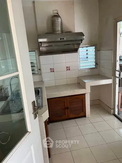 Charming kitchen with closed layout and modern range hood, perfect for culinary enthusiasts.