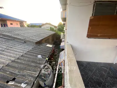 Balcony view overlooking residential rooftops and backyard area