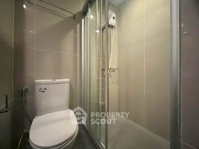 Modern bathroom with sleek shower and toilet in contemporary apartment.