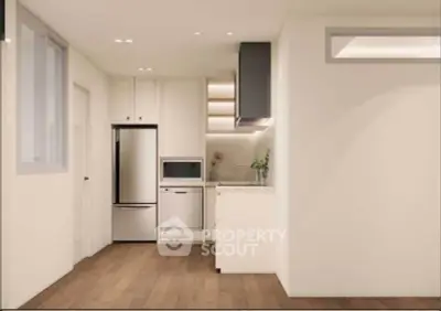 Modern minimalist kitchen with sleek appliances and wooden flooring