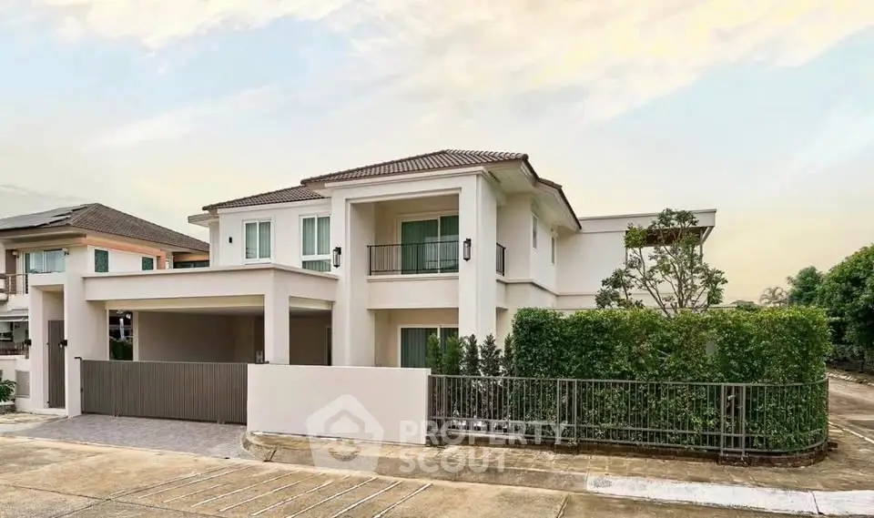 Elegant two-story house with modern design and lush greenery in a serene neighborhood.