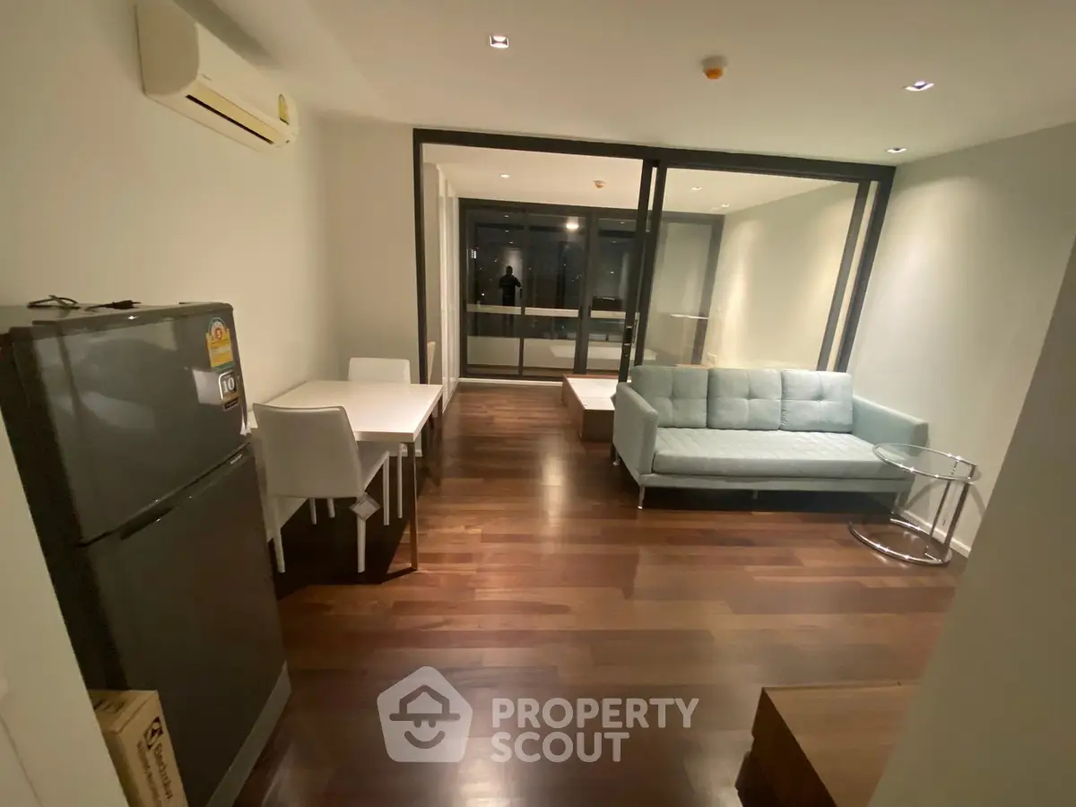 Modern living room with sleek furniture and hardwood floors in a stylish apartment.