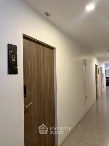 Modern apartment hallway with wooden doors and sleek lighting