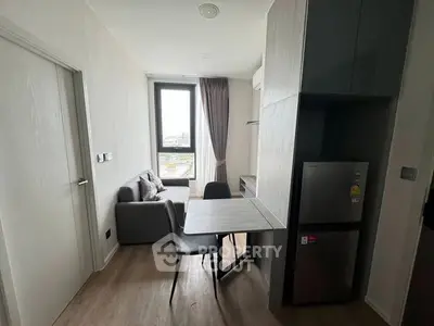 Modern compact living room with dining area and large window view.