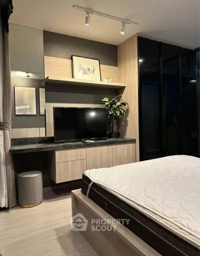 Modern bedroom with stylish decor and built-in TV unit