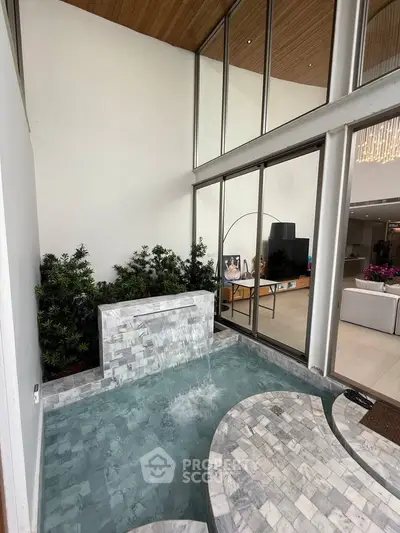 Luxurious indoor water feature in modern living space with high ceilings and natural light.