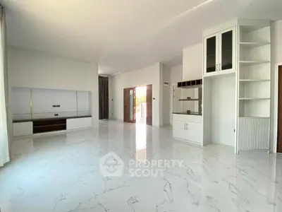 Spacious modern living room with marble flooring and built-in storage units.