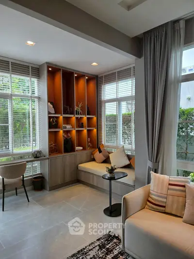 Modern living room with cozy seating and large windows offering natural light