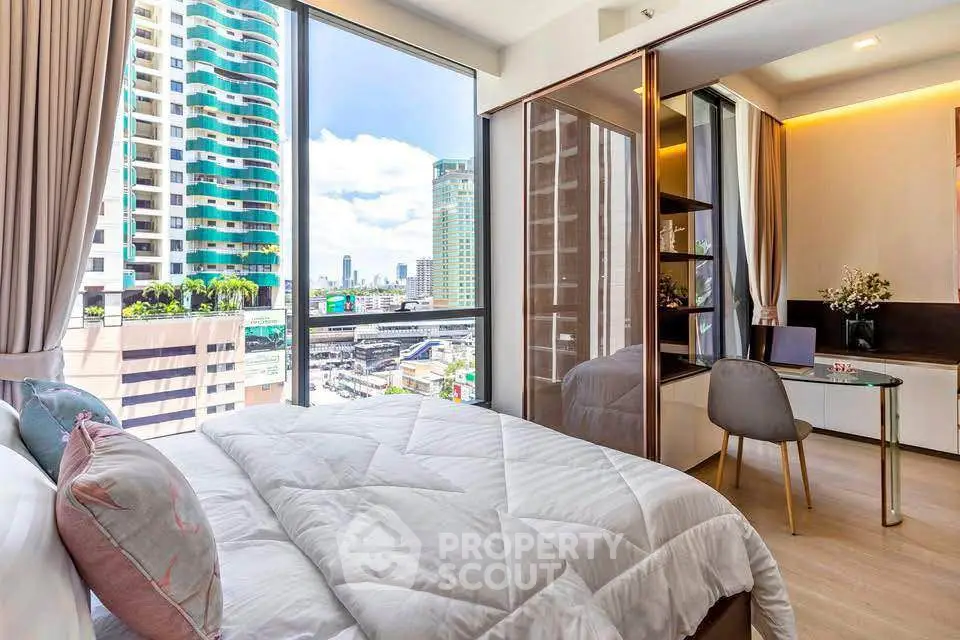 Modern bedroom with city view, featuring large windows and stylish decor in a high-rise apartment.