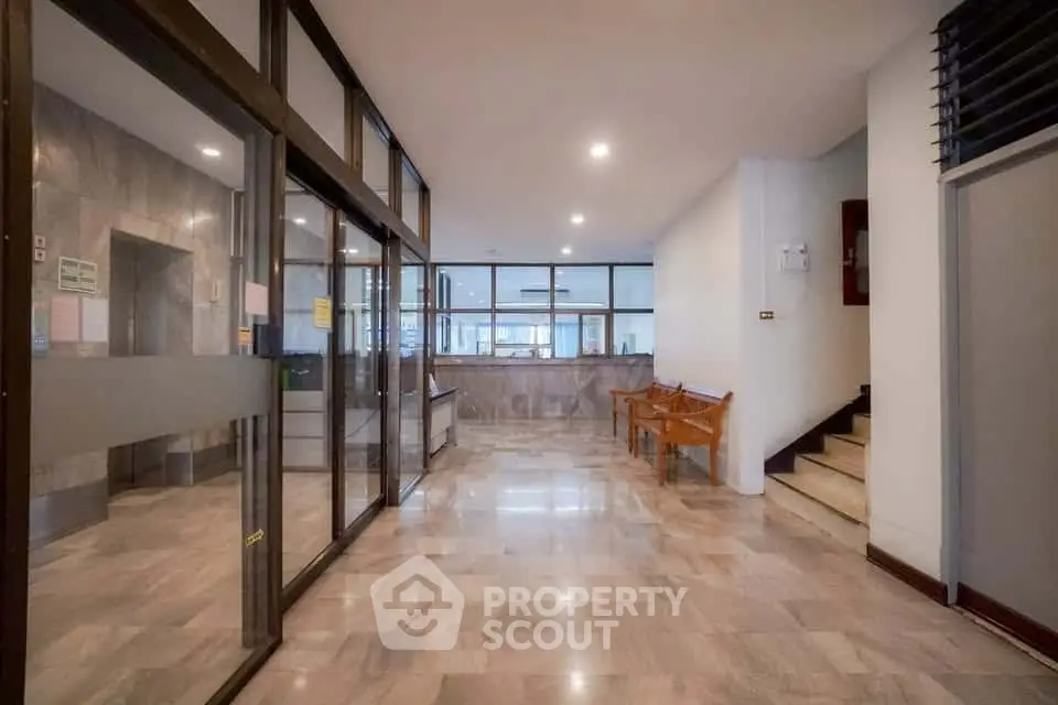 Spacious building entrance with modern glass doors and marble flooring