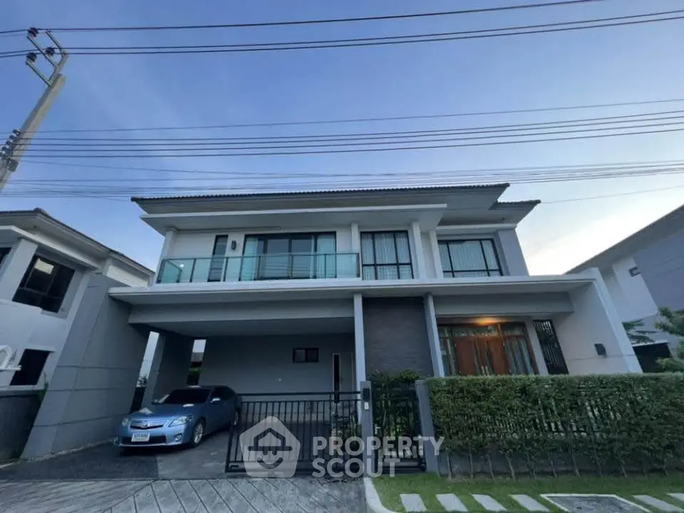 Modern two-story house with carport and landscaped front yard in a suburban neighborhood.