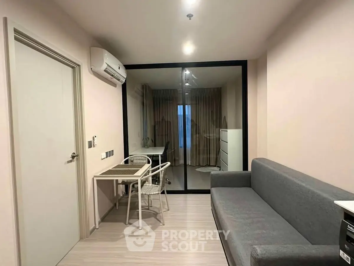 Modern apartment interior with cozy living area and glass partitioned room.