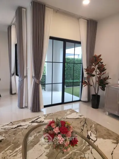 Elegant living room with modern decor and garden view through large windows