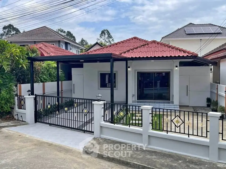 Charming single-story house with red-tiled roof and modern fence in a serene neighborhood.