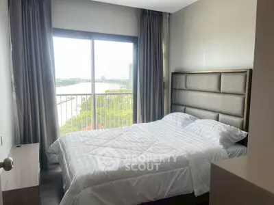 Cozy bedroom with a stunning river view, featuring a comfortable bed and large window for natural light.
