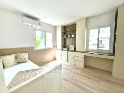 Bright and airy bedroom with modern built-in storage and large windows.
