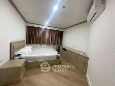 Spacious bedroom with modern design, featuring a large bed, elegant wood flooring, ample lighting, and a cozy ambiance perfect for relaxation.