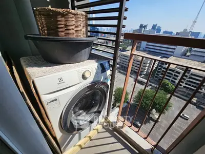 City view balcony with washing machine and basket, perfect for urban living.
