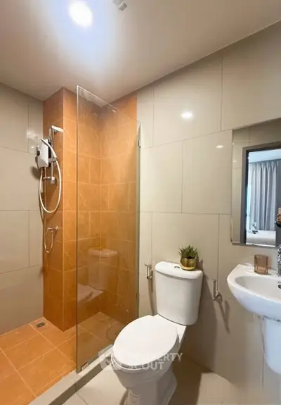 Modern bathroom with glass shower and sleek fixtures in contemporary apartment.