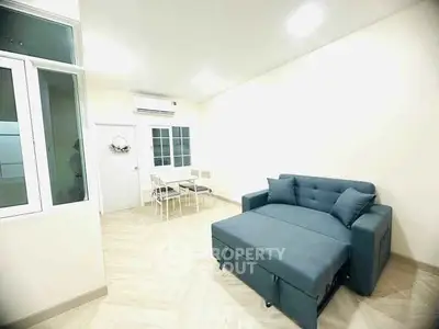 Modern living room with stylish sofa and dining area in open layout.