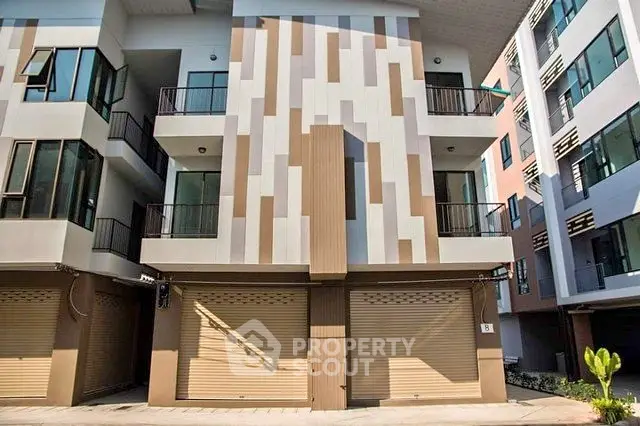 Modern multi-story building with unique facade design and balconies, ideal for urban living.