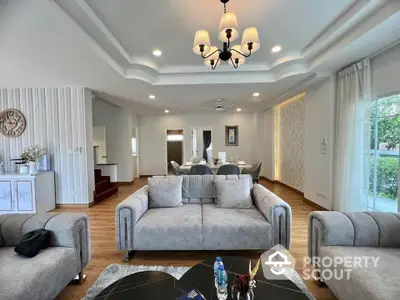 Spacious living room with elegant decor and modern furnishings, featuring a cozy seating area and stylish lighting.