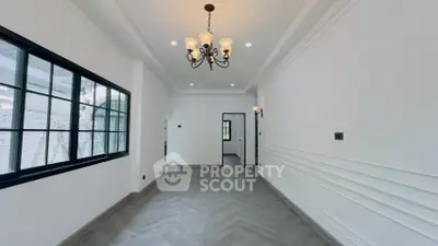 Spacious empty room with elegant chandelier and large window