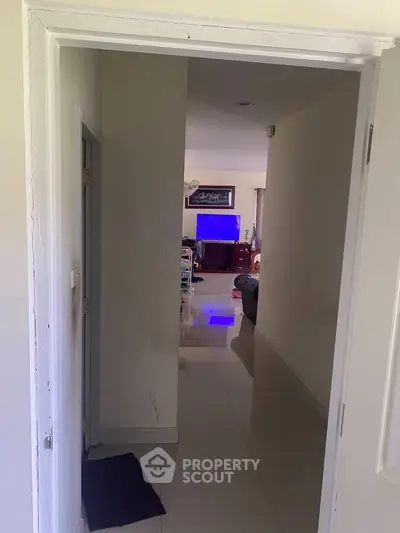 Spacious living area with modern decor and sleek flooring, perfect for comfortable living.