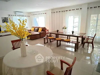 Spacious living room with elegant dining area and cozy seating, perfect for family gatherings.