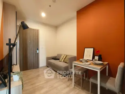 Cozy modern living room with orange accent wall and dining area, perfect for urban living.