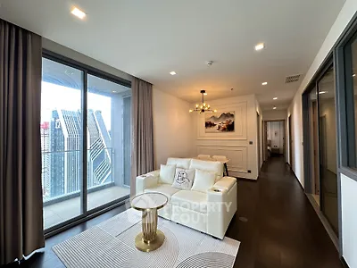 Luxurious living room with modern decor and stunning city view from balcony.