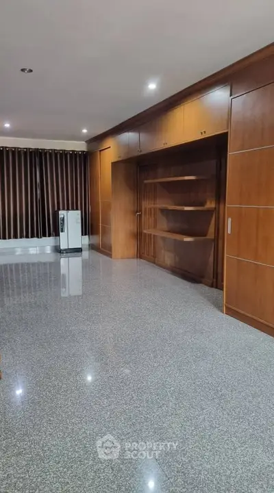Spacious living room with elegant wooden cabinetry and polished flooring