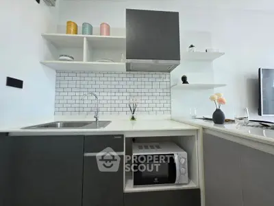 Modern kitchen with sleek cabinetry, built-in microwave, and stylish open shelving.